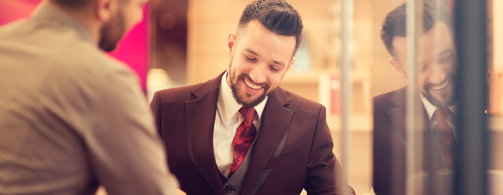 Male employee smiling, glass reflection