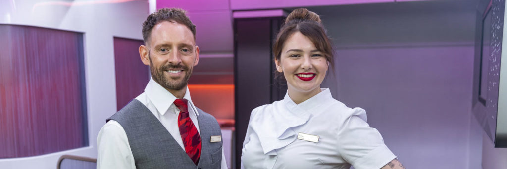 Two Virgin Atlantic Cabin crew in uniform showing tattoos