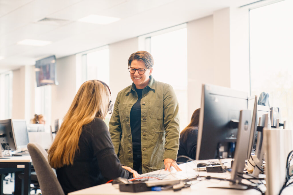 Two Virgin Atlantic employees talking at a desk