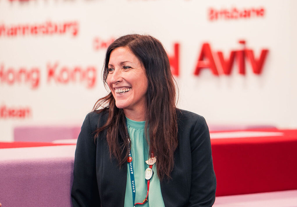 Virgin Atlantic employee sitting on a couch and smiling