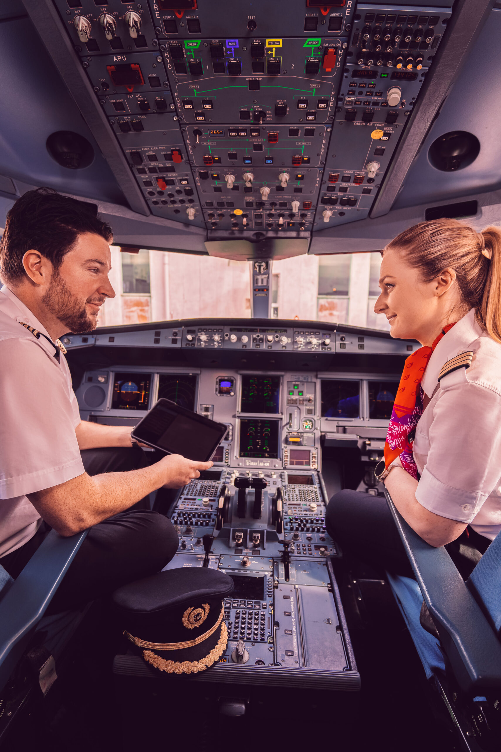 Inside a Virgin Atlantic airplane cockpit, two pilots are seated, engaged in operating the aircraft's controls