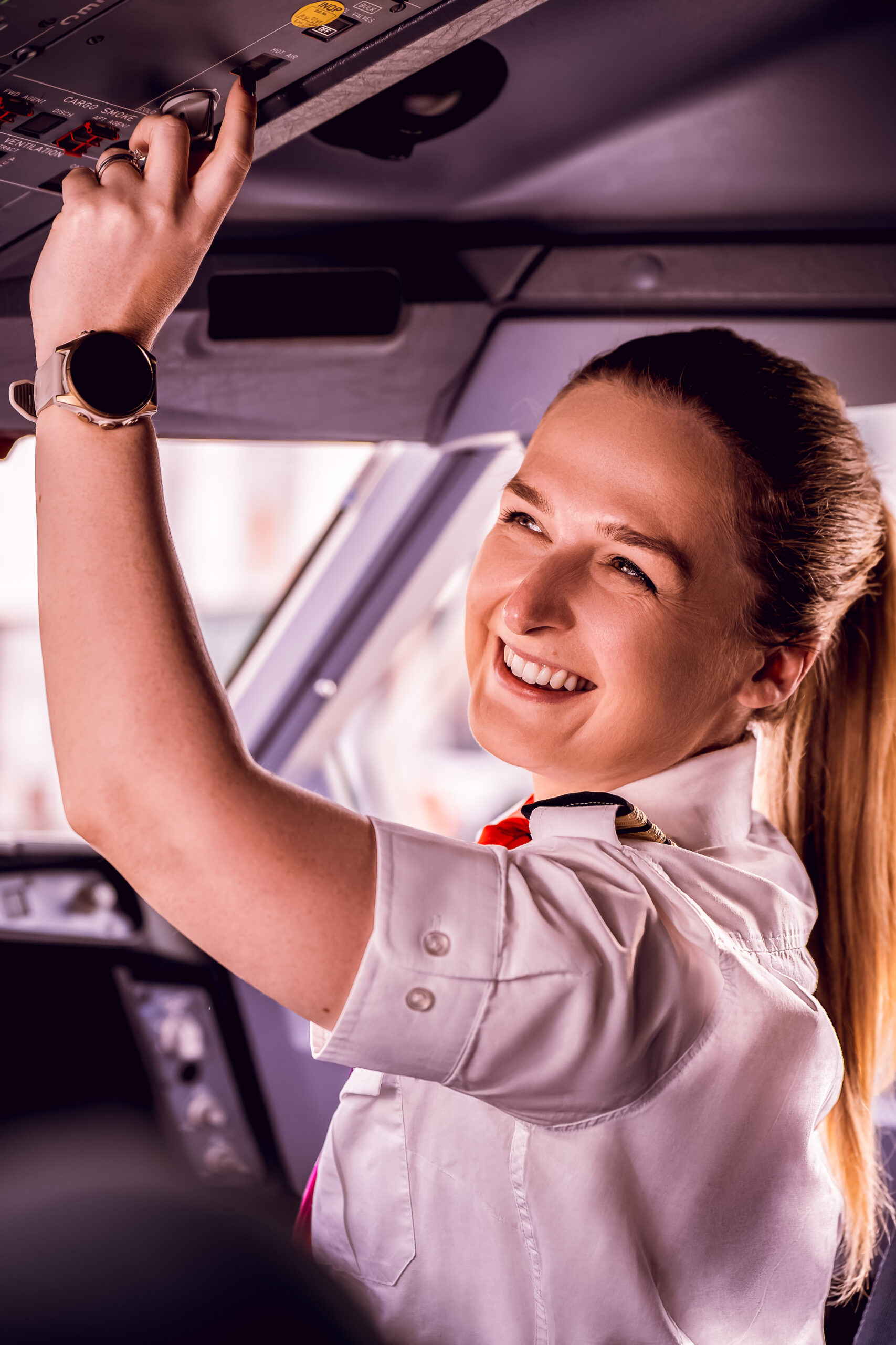 A smiling woman in a Virgin Atlantic pilot uniform sits in the cockpit