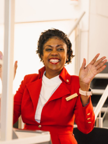 Airport worker smiling and welcoming passengers seated behind a check-in desk