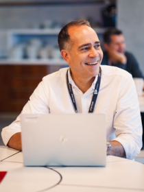Virgin Atlantic employee working on a laptop and smiling