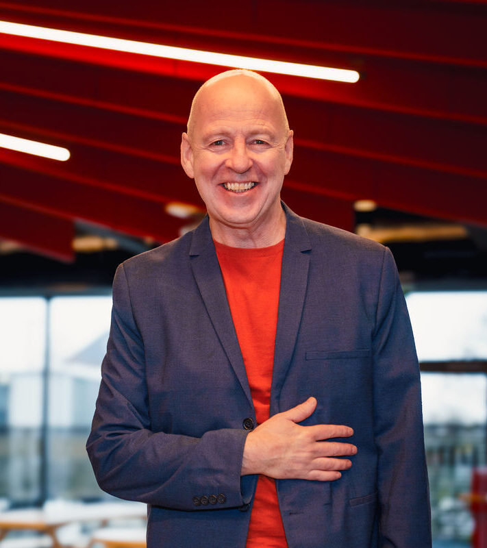 Virgin Atlantic employee wearing a red t-shirt and navy jacket