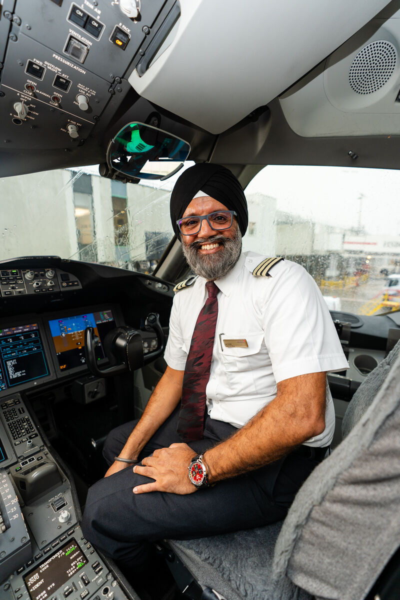 Virgin Atlantic pilot in uniform sitting in the cockpit