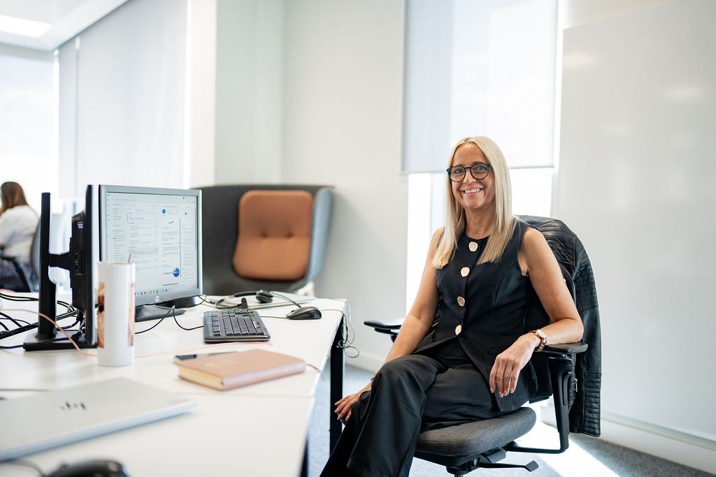 Virgin Atlantic employee sitting at a desk with a computer monitor